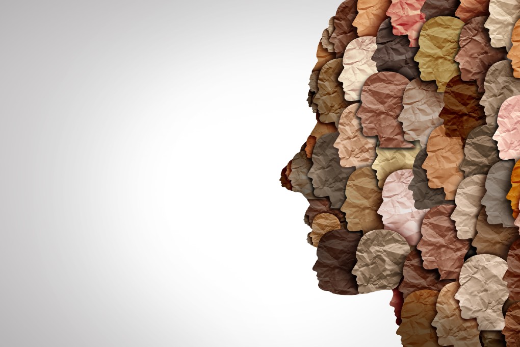 Photo of a collage of paper faces with different colors representing diversity 
